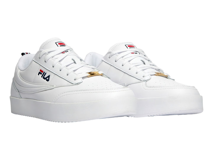 Tenis FILA blancos de corte bajo con suela gruesa y logotipo lateral en colores azul y rojo.