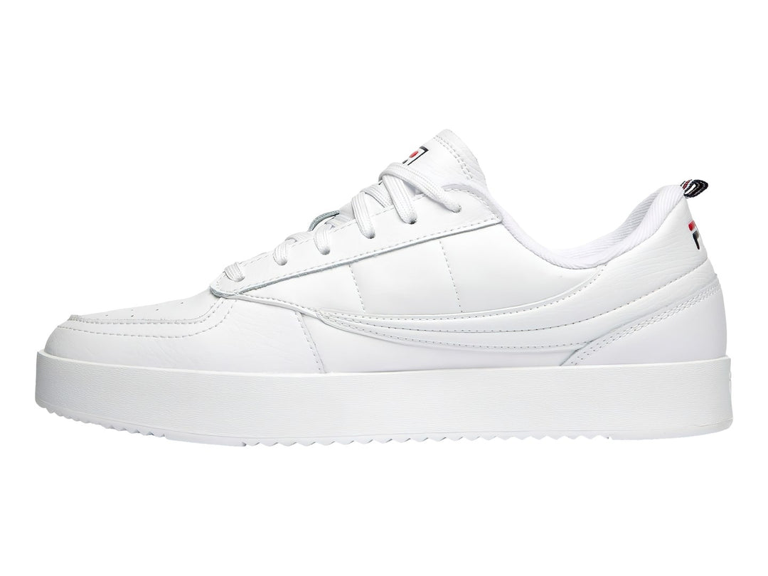 Tenis FILA blancos de corte bajo con suela gruesa y logotipo lateral en colores azul y rojo.