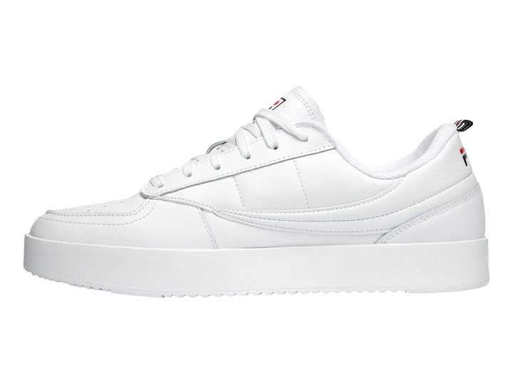 Tenis FILA blancos de corte bajo con suela gruesa y logotipo lateral en colores azul y rojo.