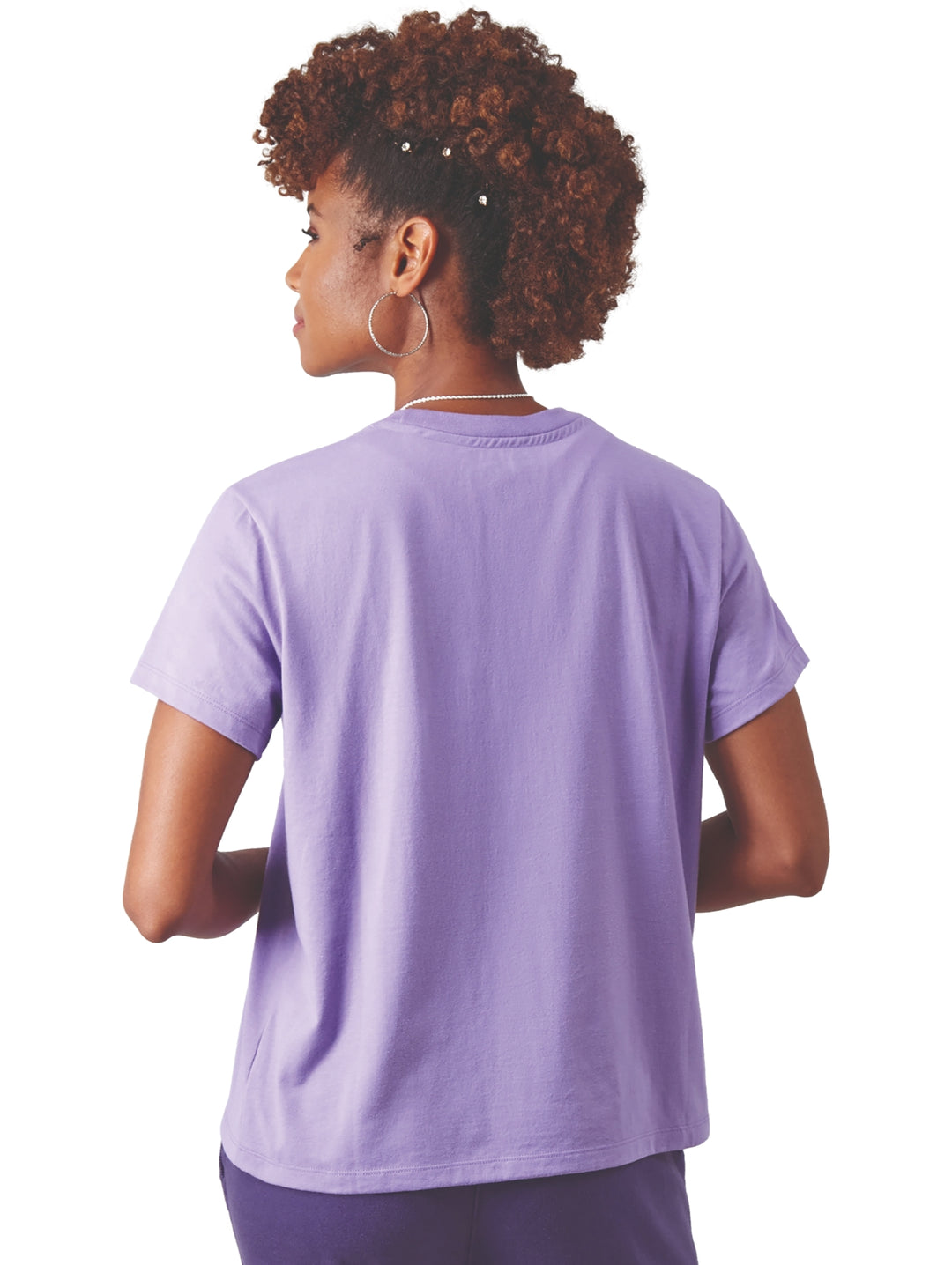 Mujer vistiendo una camiseta Champion color lavanda y pantalones deportivos morados.