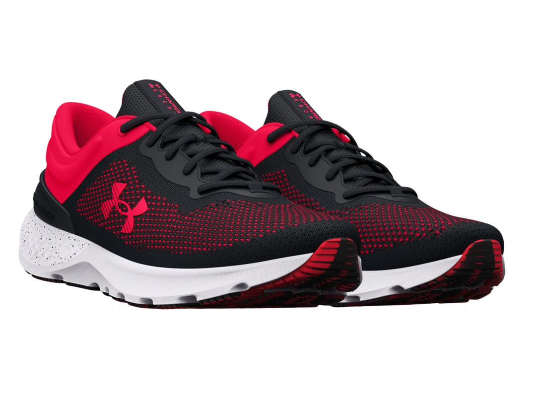 Tenis deportivos Under Armour en colores negro y rosa con suela blanca y tejido transpirable.