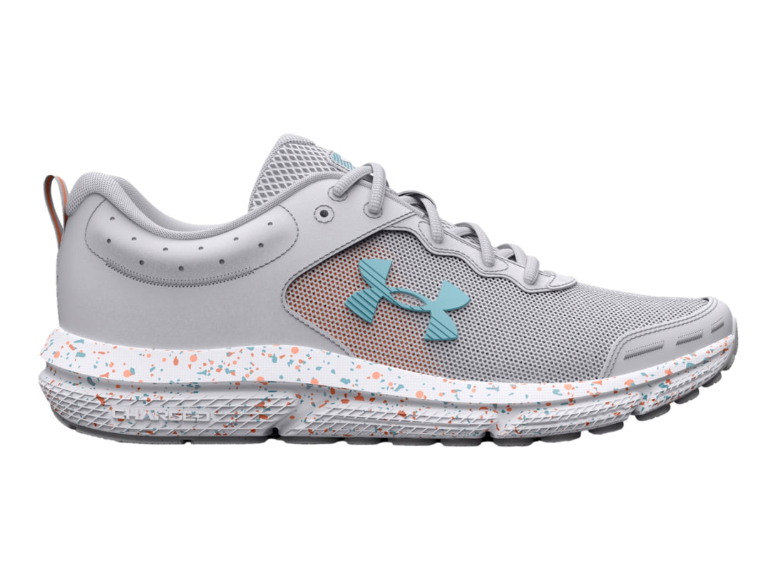 Tenis deportivos Under Armour color gris con suela blanca moteada y logotipo azul claro.