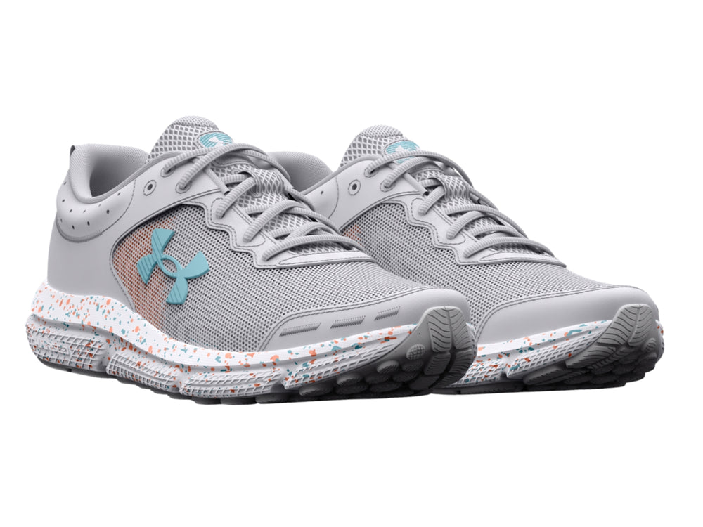 Tenis deportivos Under Armour color gris con suela blanca moteada y logotipo azul claro.