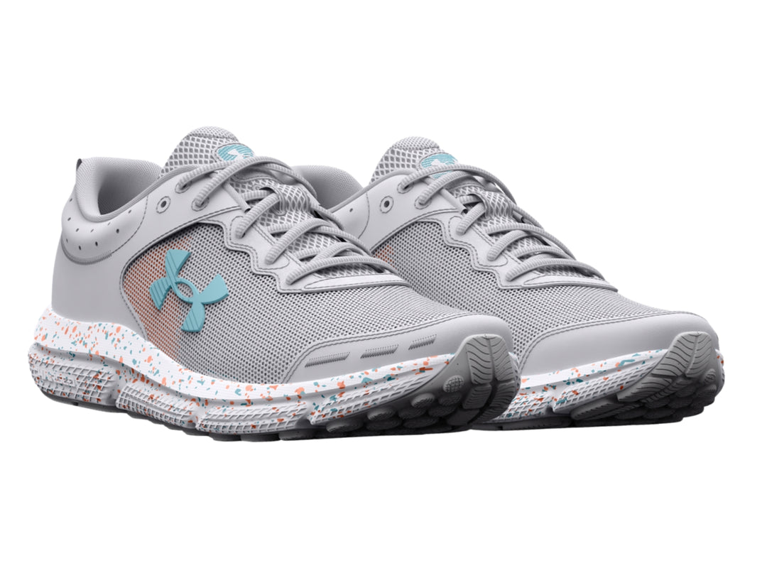 Tenis deportivos Under Armour color gris con suela blanca moteada y logotipo azul claro.
