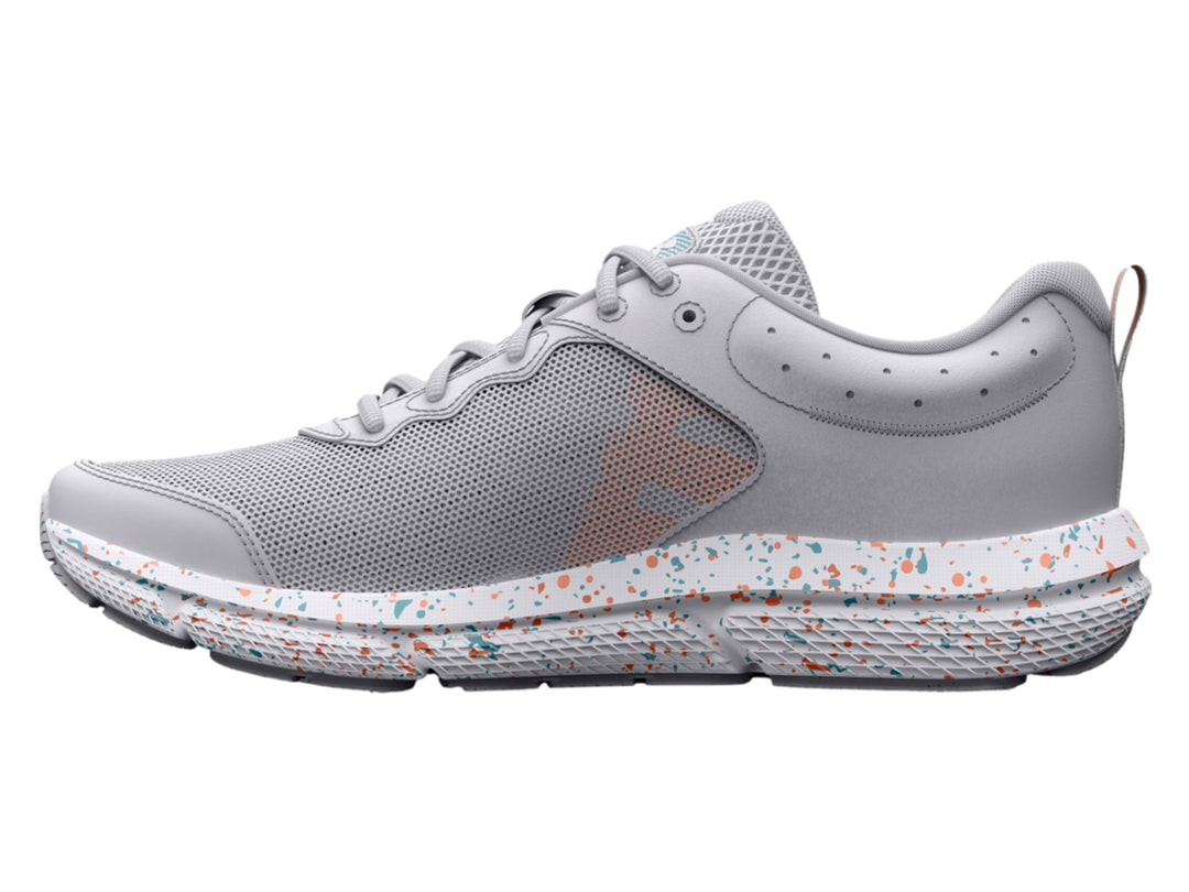 Tenis deportivos Under Armour color gris con suela blanca moteada y logotipo azul claro.