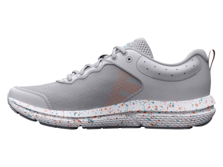 Tenis deportivos Under Armour color gris con suela blanca moteada y logotipo azul claro.