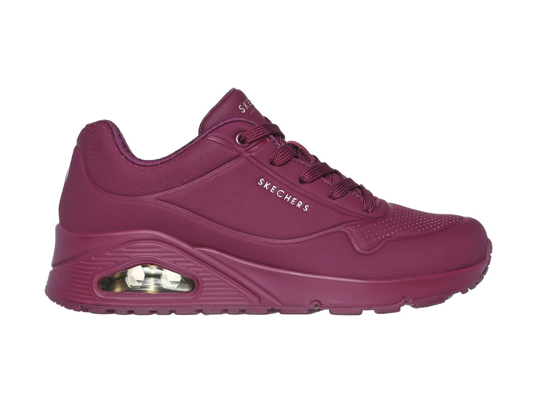 Tenis Skechers color vino con amortiguación visible en el talón y agujetas a juego.