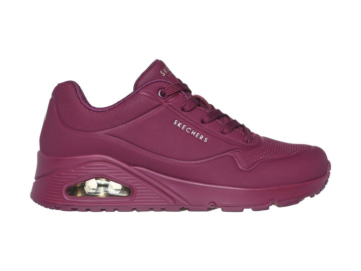 Tenis Skechers color vino con amortiguación visible en el talón y agujetas a juego.