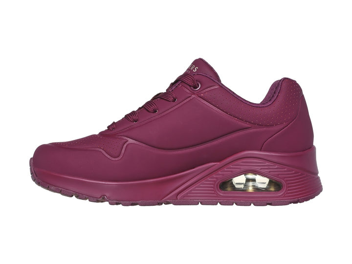 Tenis Skechers color vino con amortiguación visible en el talón y agujetas a juego.
