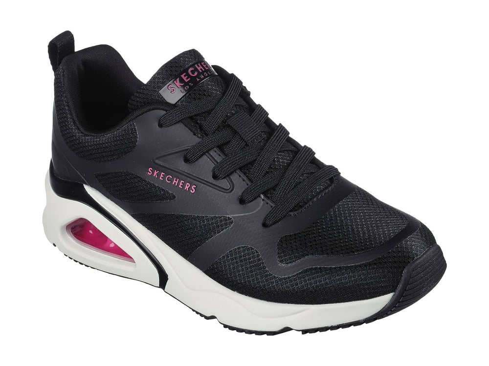 Tenis deportivos Skechers color negro con suela blanca y cámara de aire rosa en el talón.