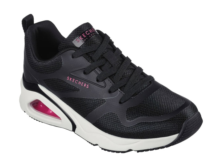 Tenis deportivos Skechers color negro con suela blanca y cámara de aire rosa en el talón.
