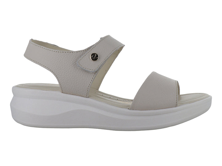 Sandalia color hueso con suela blanca de plataforma y correa ajustable al tobillo.