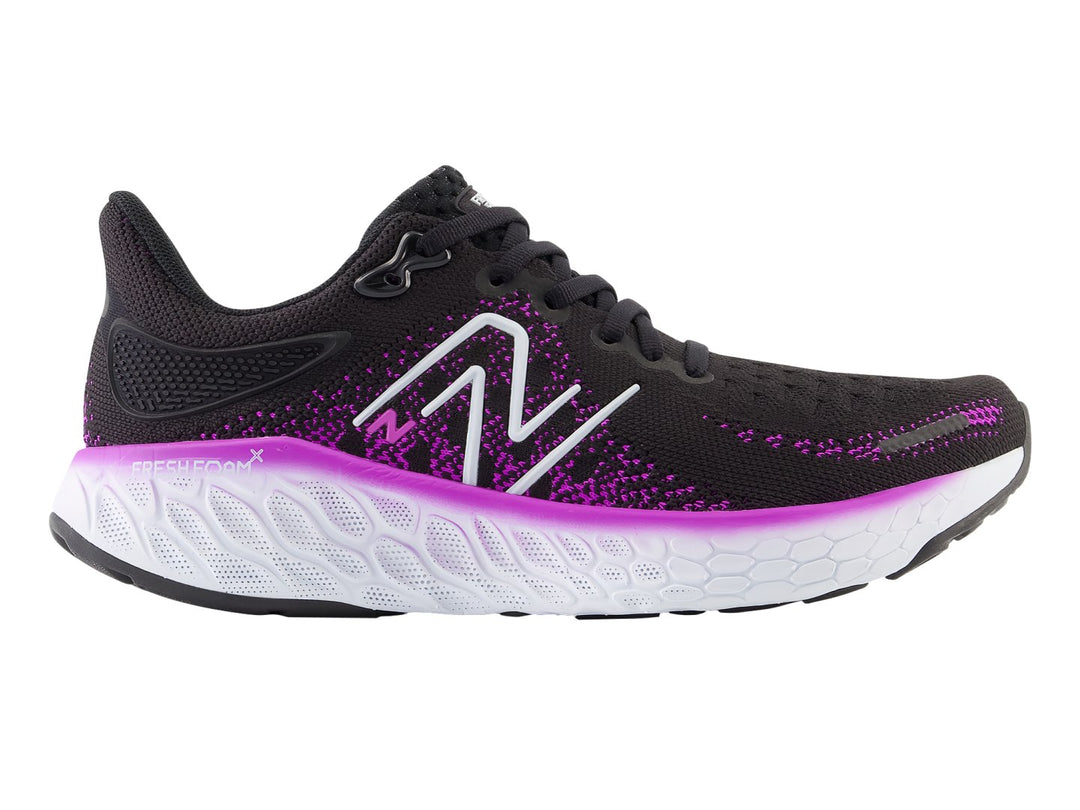 Tenis New Balance color negro con detalles en morado y suela blanca para mujer.
