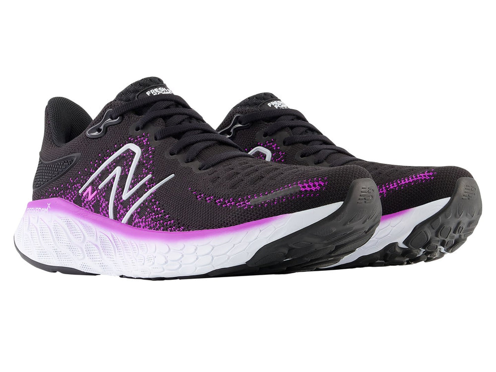 Tenis New Balance color negro con detalles en morado y suela blanca para mujer.