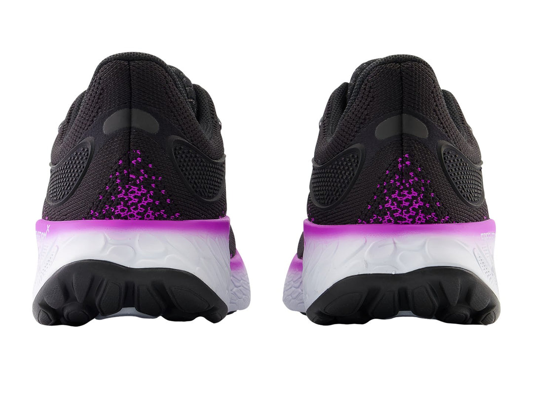 Tenis New Balance color negro con detalles en morado y suela blanca para mujer.