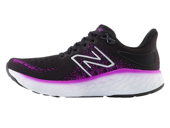 Tenis New Balance color negro con detalles en morado y suela blanca para mujer.