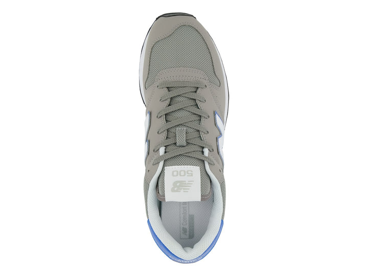 Tenis New Balance color gris con detalles en azul, suela blanca y negra.