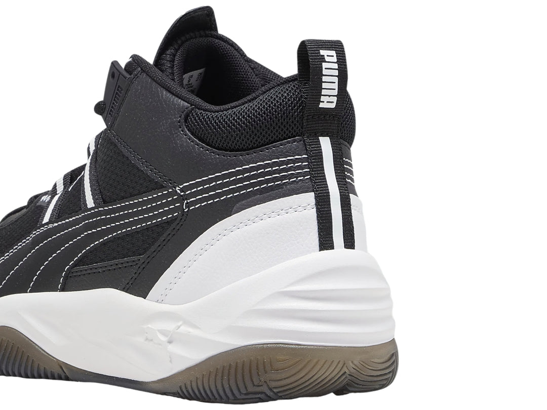 Tenis de baloncesto PUMA Rebound Future Nextgen en color negro con suela blanca y detalles en gris.