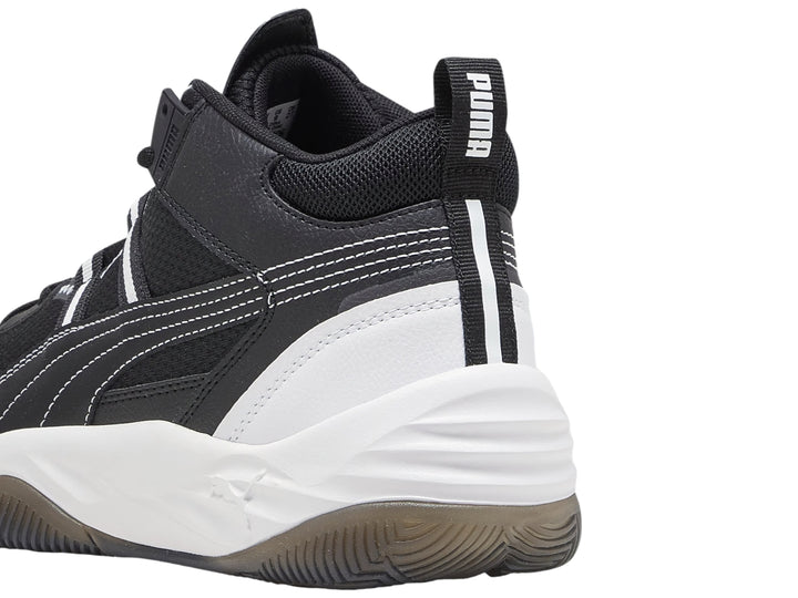 Tenis de baloncesto PUMA Rebound Future Nextgen en color negro con suela blanca y detalles en gris.