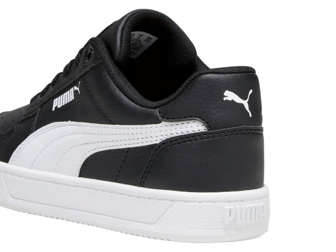 Tenis PUMA Caven 2.0 JR color negro con suela y franja lateral blanca.