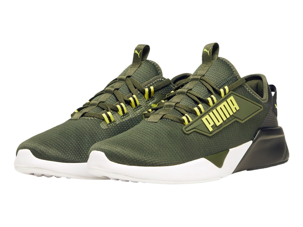 Tenis deportivos PUMA color verde oliva con suela blanca y negra y detalles amarillos.
