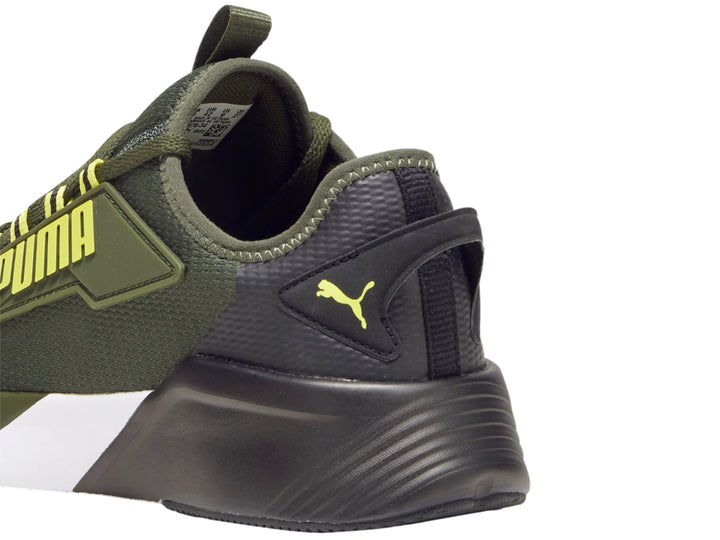 Tenis deportivos PUMA color verde oliva con suela blanca y negra y detalles amarillos.