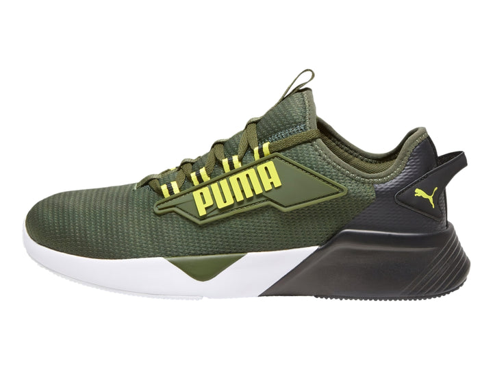 Tenis deportivos PUMA color verde oliva con suela blanca y negra y detalles amarillos.