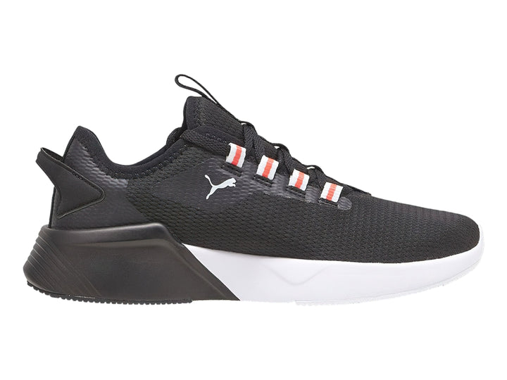 Tenis deportivos PUMA color negro con suela blanca y detalles naranjas en los ojales.