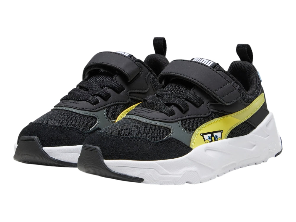 Tenis PUMA infantiles color negro con detalles en amarillo y blanco, suela blanca robusta y cierre de velcro.