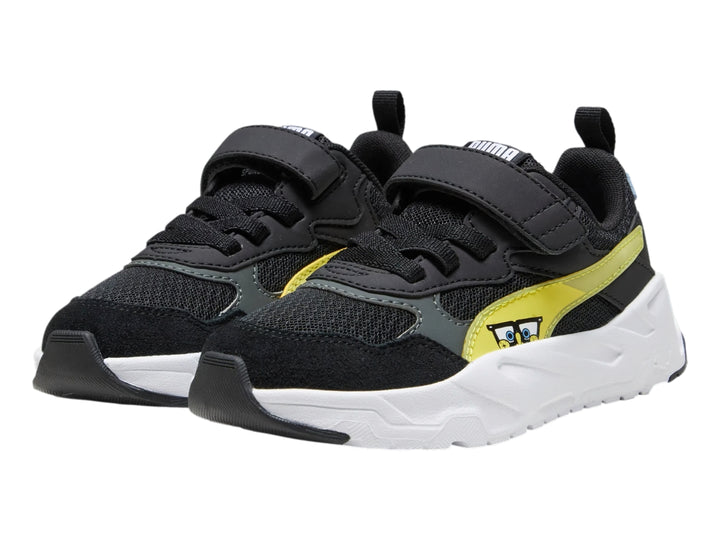 Tenis PUMA infantiles color negro con detalles en amarillo y blanco, suela blanca robusta y cierre de velcro.