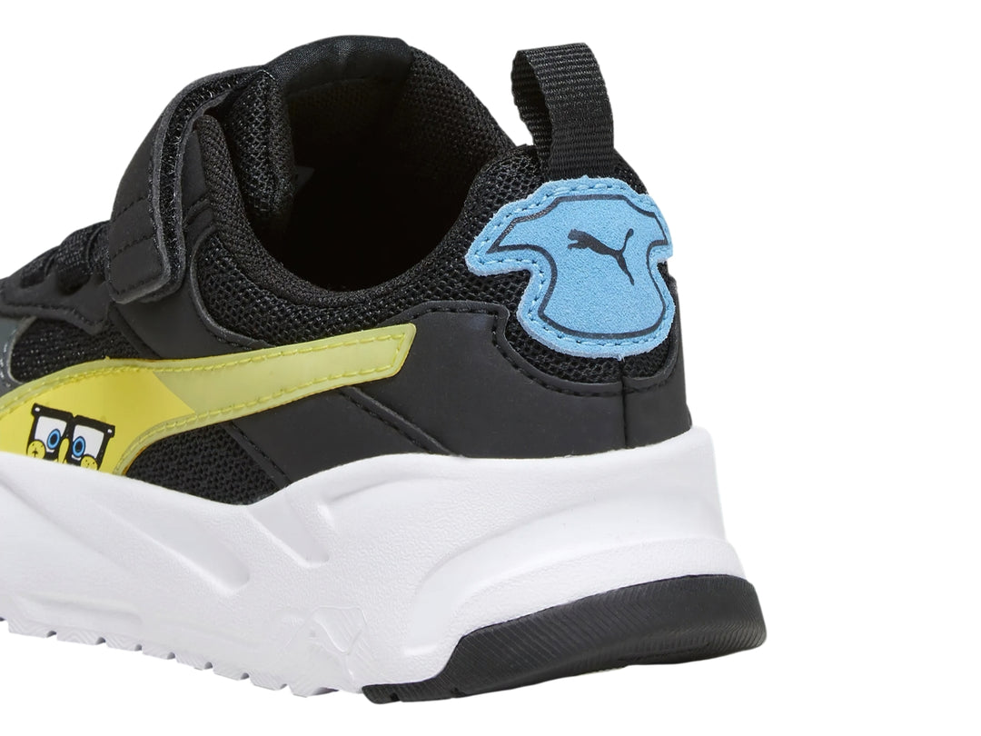 Tenis PUMA infantiles color negro con detalles en amarillo y blanco, suela blanca robusta y cierre de velcro.