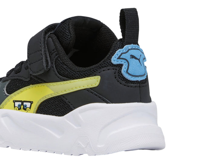Tenis PUMA infantiles color negro con franja amarilla y suela blanca gruesa.