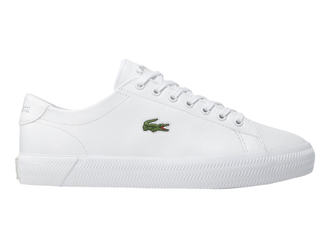 Tenis blancos de cuero marca Lacoste con logotipo de cocodrilo verde en el lateral.