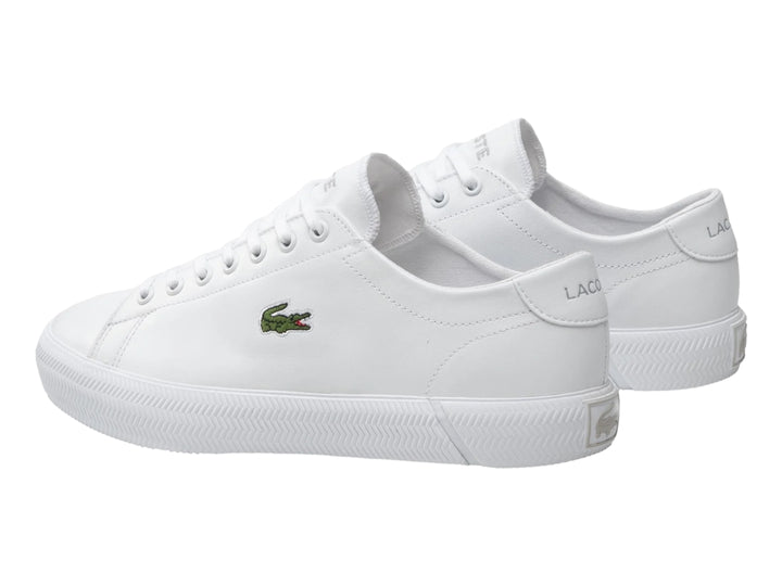 Tenis blancos de cuero marca Lacoste con logotipo de cocodrilo verde en el lateral.
