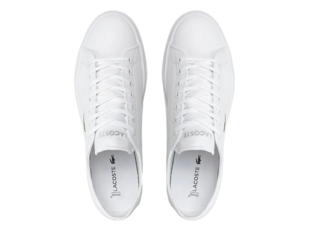 Tenis blancos de cuero marca Lacoste con logotipo de cocodrilo verde en el lateral.