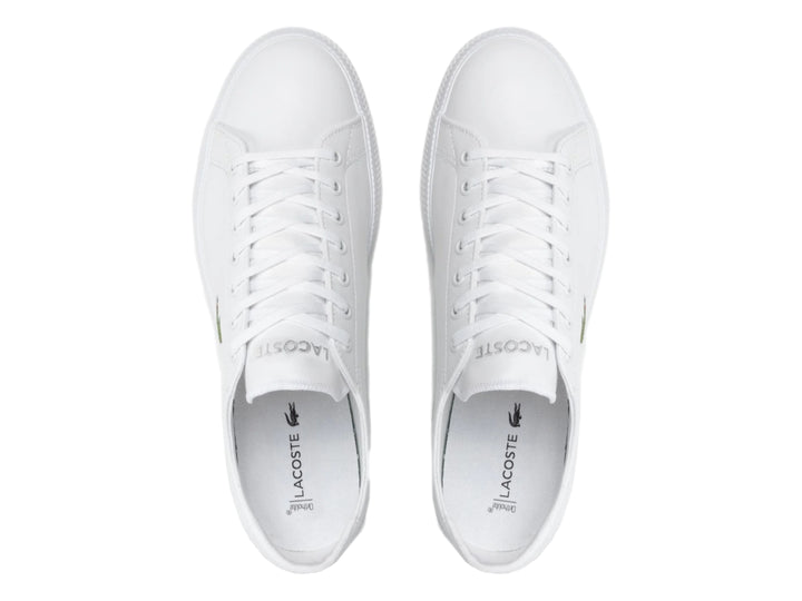 Tenis blancos de cuero marca Lacoste con logotipo de cocodrilo verde en el lateral.