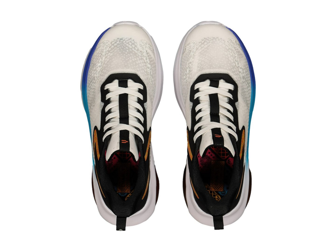 Tenis deportivos Charly blancos y negros con detalles naranjas y suela blanca con cámara de aire visible.