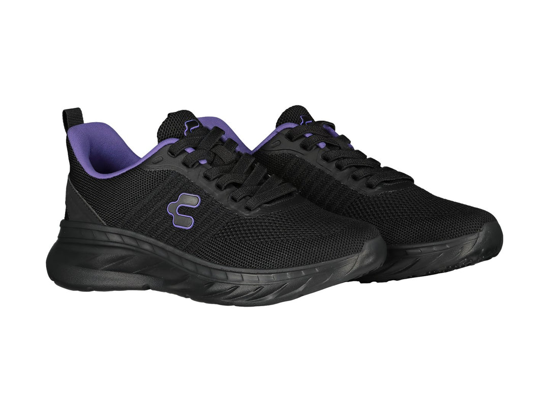 Tenis deportivos color negro con detalles en morado y suela gruesa.