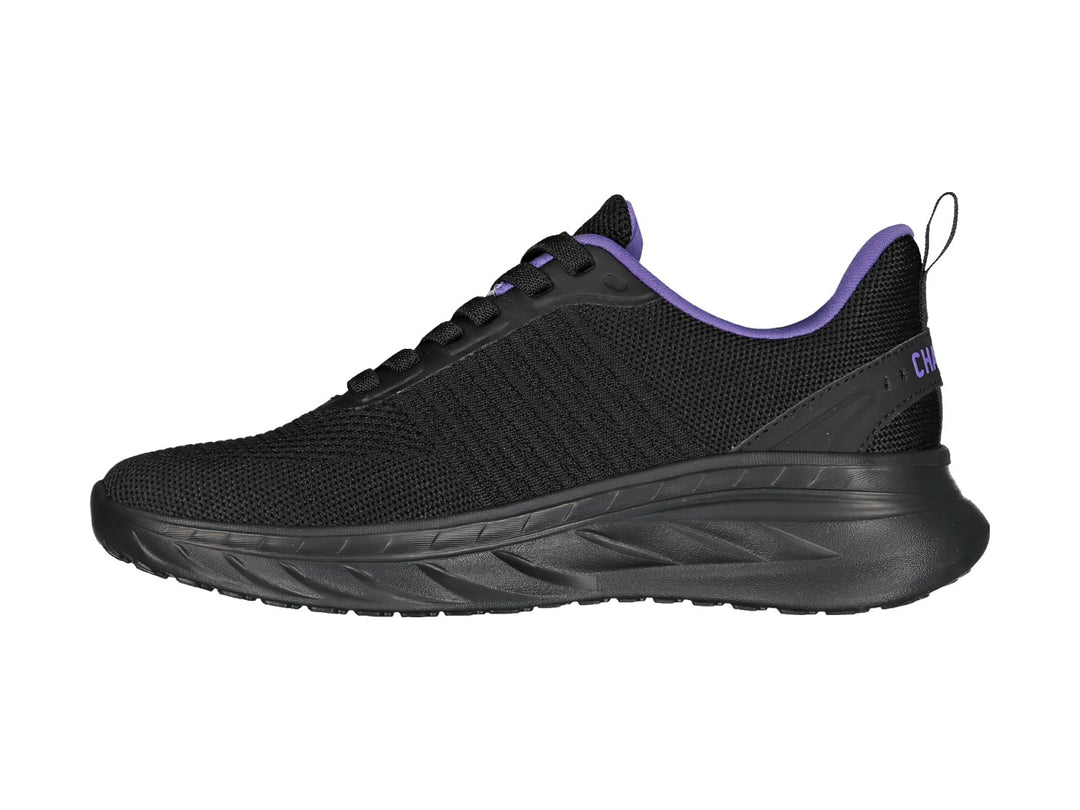 Tenis deportivos color negro con detalles en morado y suela gruesa.
