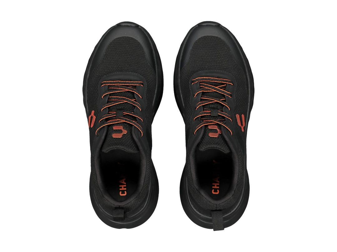 Tenis deportivos Charly color negro con detalles en naranja y suela gruesa amortiguada.