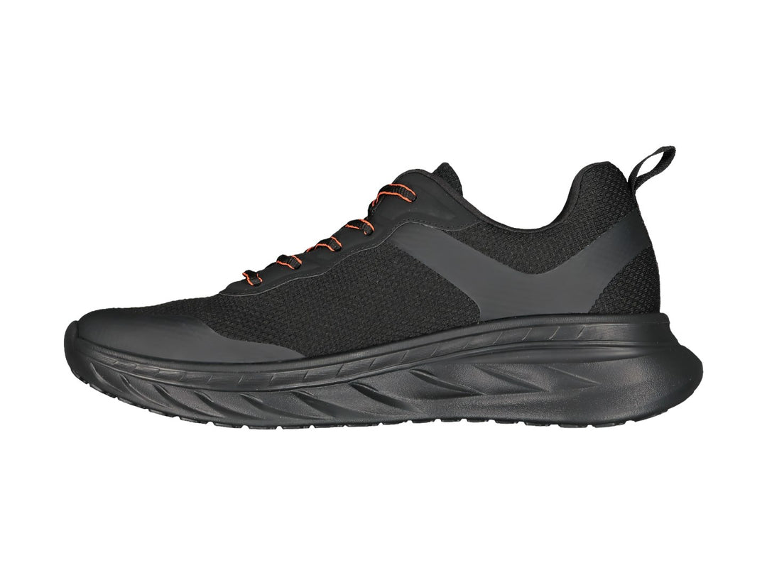 Tenis deportivos Charly color negro con detalles en naranja y suela gruesa amortiguada.