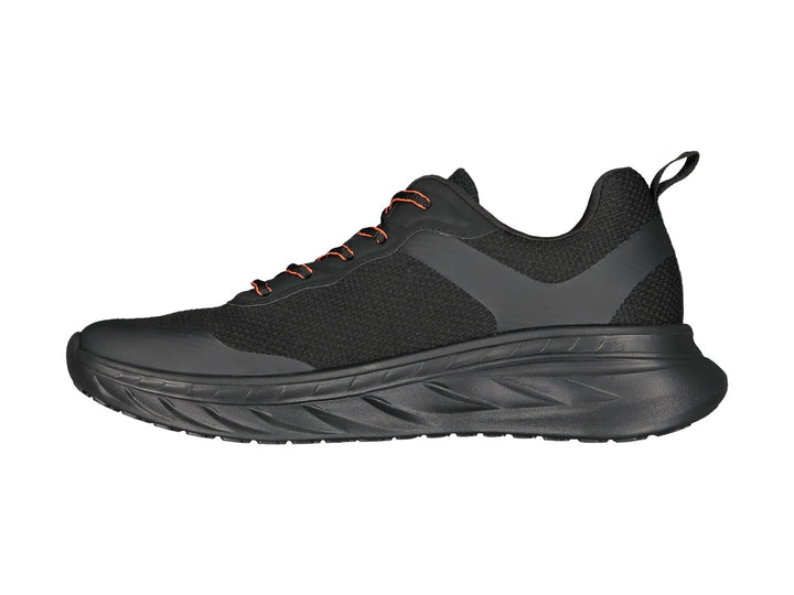 Tenis deportivos Charly color negro con detalles en naranja y suela gruesa amortiguada.