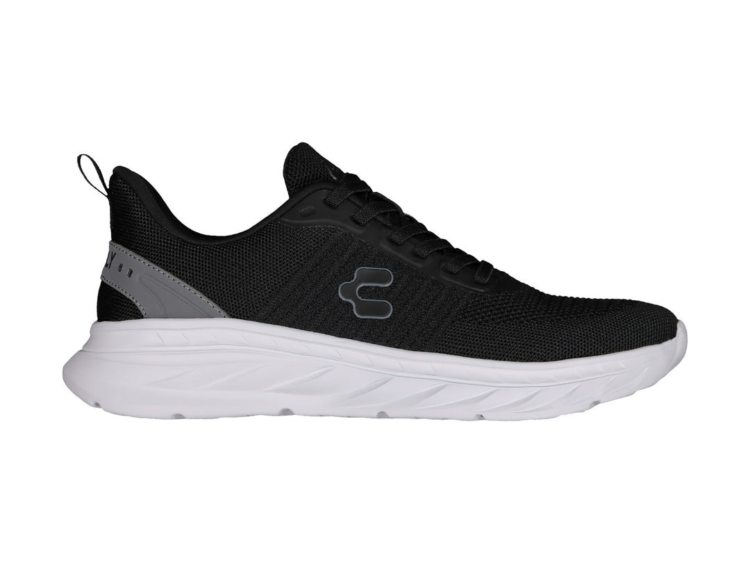Tenis deportivos Charly color negro con suela blanca y detalle gris en el talón.