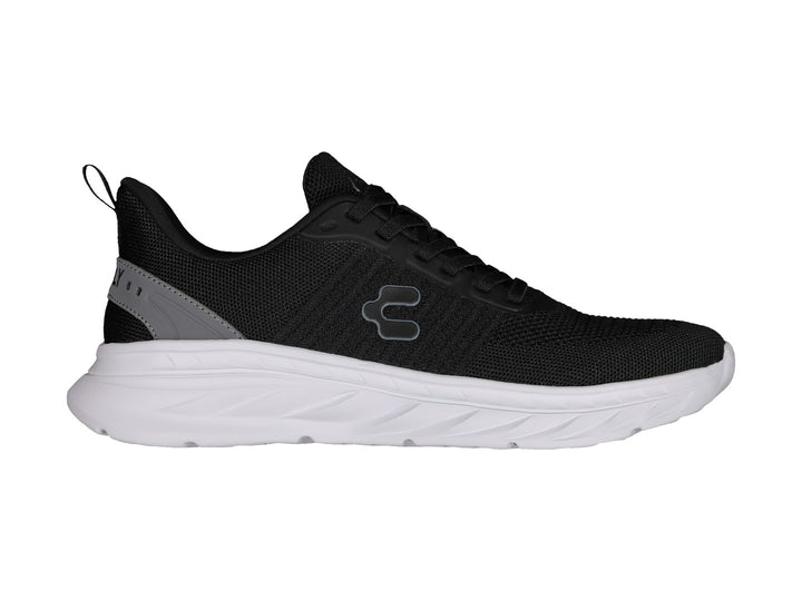 Tenis deportivos Charly color negro con suela blanca y detalle gris en el talón.