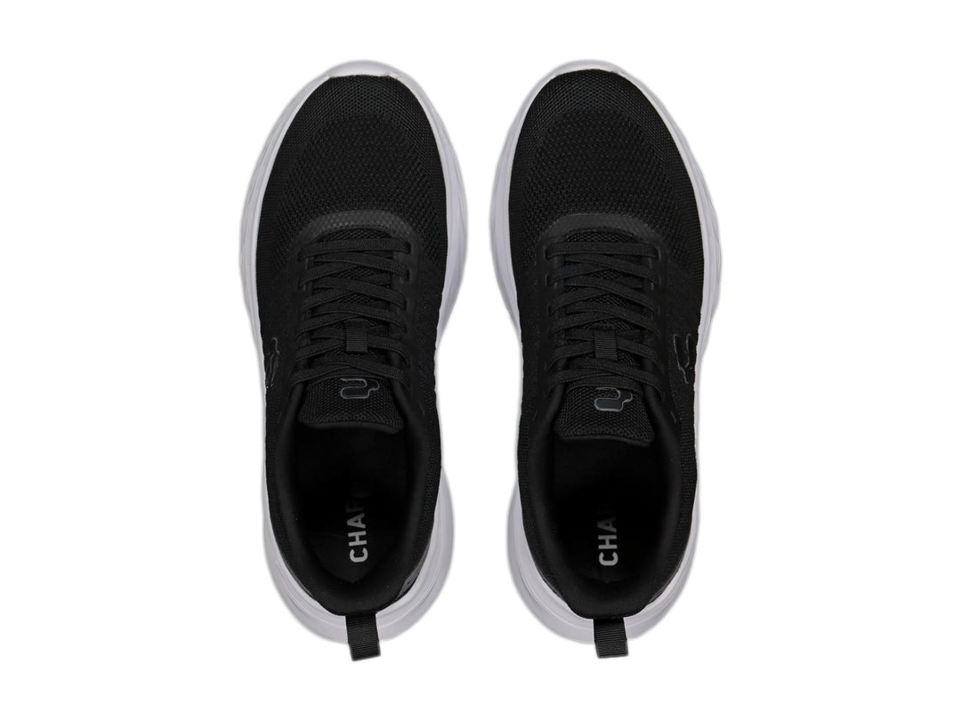 Tenis deportivos Charly color negro con suela blanca y detalle gris en el talón.