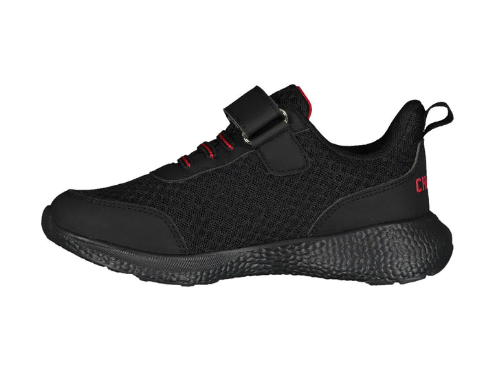 Zapato deportivo negro Charly con detalles en rojo y correa de velcro.