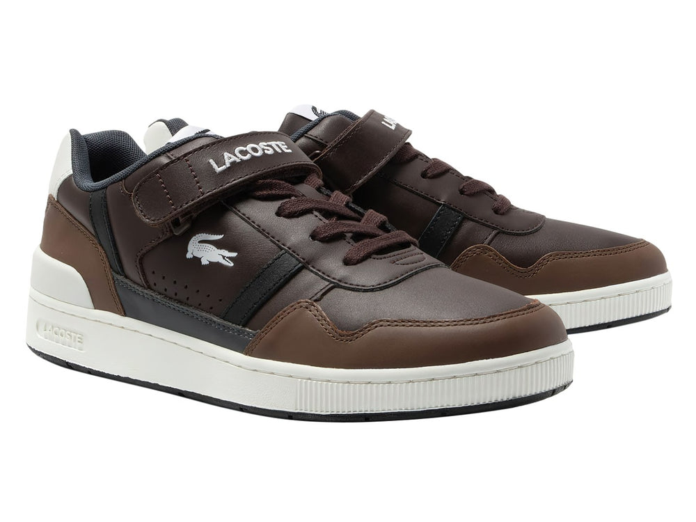 Tenis Lacoste color marrón oscuro con suela blanca y correa de velcro.