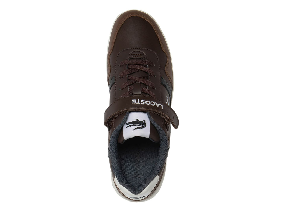 Tenis Lacoste color marrón oscuro con suela blanca y correa de velcro.