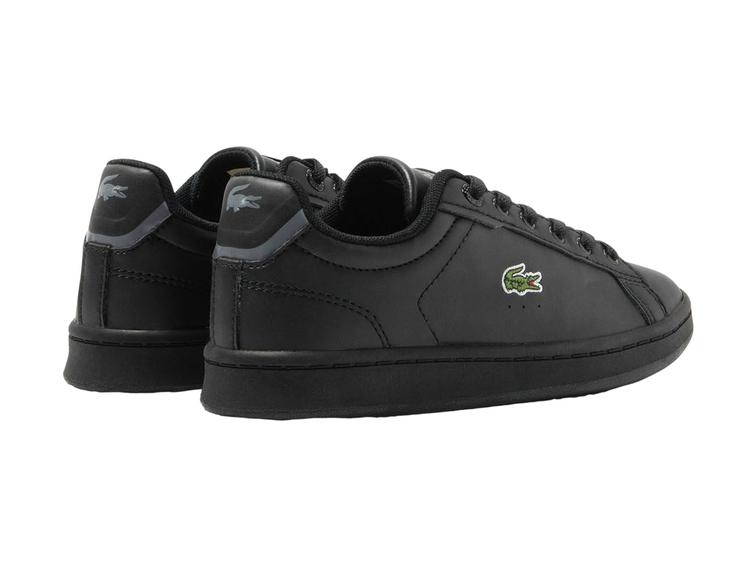 Tenis negros Lacoste modelo Carnaby Pro con logotipo del cocodrilo en el costado y suela negra.