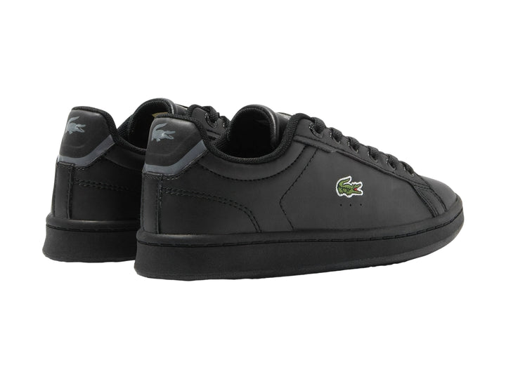 Tenis negros Lacoste modelo Carnaby Pro con logotipo del cocodrilo en el costado y suela negra.